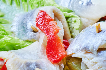 Rolled herrings in vinegar with onions, peppers and pickles