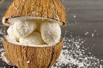 Fresh coconut and coconut cookies on dark background