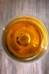 Glass of wine on wooden table. Top view