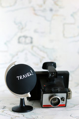 Camera and globe with travel letters on it