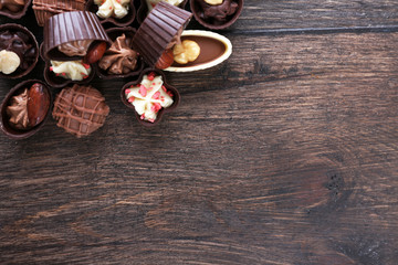 Fototapeta na wymiar Delicious chocolate candies on wooden background, close up