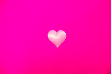 White love heart in the middle on a pink background, bright pink background with heart
