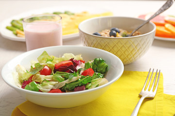 Tasty oatmeal and vegetable salad on wooden background. Healthy eating concept.