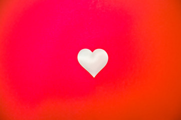 White love heart in the middle on a red background, bright red background with a heart