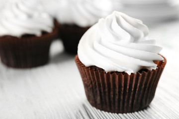 White cupcakes on wooden table