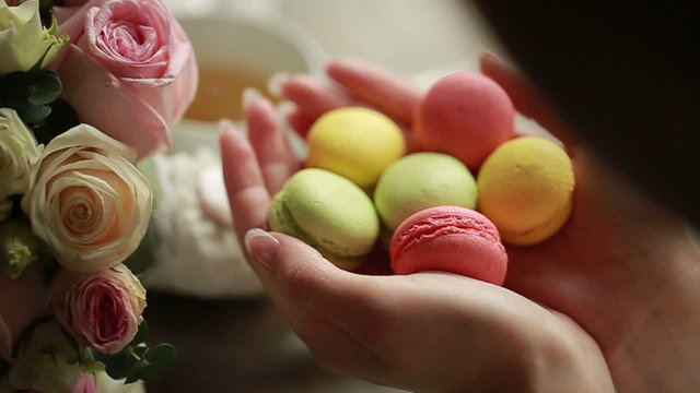 Close-up of  colorful macaron (macaroon) in woman's hand 