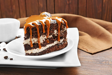 Piece of chocolate cake with caramel in white plate closeup
