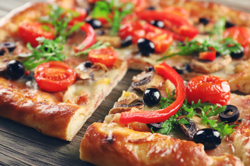 Freshly homemade pizza on wooden table closeup