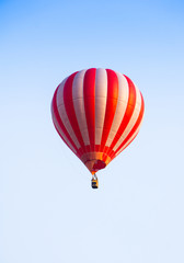 Red and white  hot air balloon floating on air in sunset light