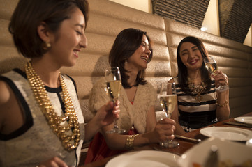 Three women are drinking champagne in a luxurious restaurant