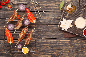 Bacon grilled on skewers on the grill grate