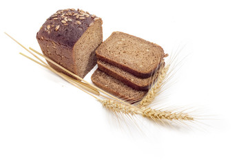 Brown bread with grain of sunflowers and wheat spikes