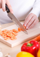 Close-up of female cutting vegetables on a kitchen cutting board