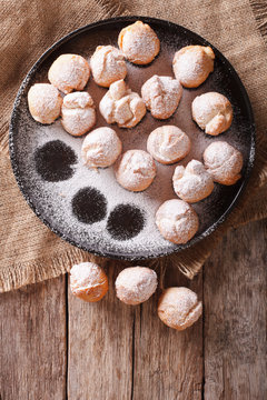 Italian donuts Castagnole on a plate on the table. vertical top view 
