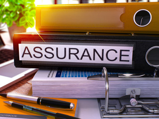 Obraz premium Black Office Folder with Inscription Assurance on Office Desktop with Office Supplies and Modern Laptop. Assurance Business Concept on Blurred Background. Assurance - Toned Image. 3D.