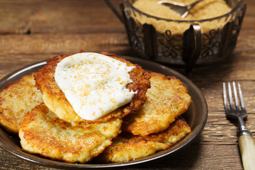 Homemade potato pancakes served with sour cream and brown sugar