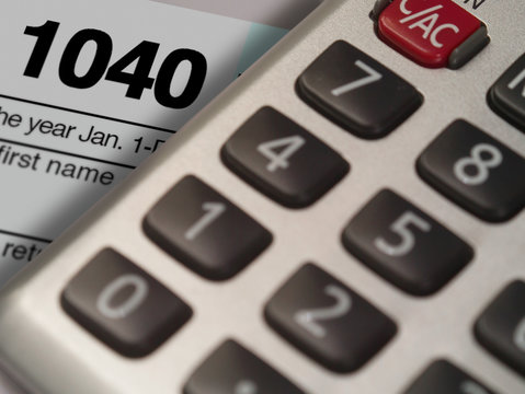 Photograph of a calculator and IRS 1040 form in close up.