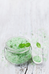 Sea salt bath scented mint for spa and aromatherapy on white wooden background, rustic style