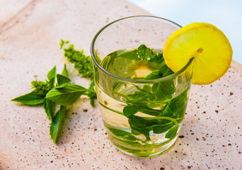 Fresh cocktail with herbal mint tea and lemon iced tea on stone