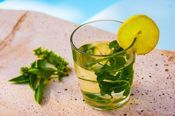 Fresh cocktail with herbal mint tea and lemon iced tea on stone