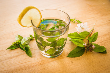 beautiful green tea with mint and lemon on wooden table with whi