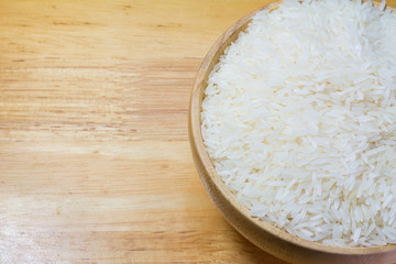Fototapeta na wymiar Rice in wooden bowl on Sack or wood table background