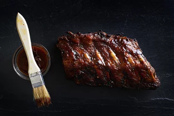 Gordijnen baby back barbecued ribs top down photo on slate © Joshua Resnick