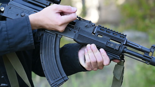 hand men black jacket pull the breech of the rifle