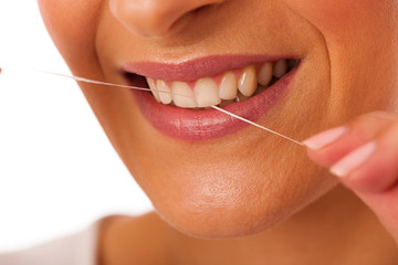 Obraz premium Woman cleaning teeth with dental floss for perfect hygiene and h