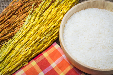 Rice in wooden bowl on Sack or wood table background
