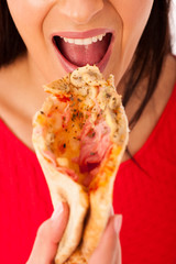 Woman eating tasty piece of pizza. Unhealthy fast food meal.