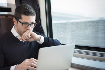 man working with computer on a train