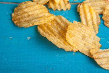 potato chips scattered on a blue wooden table