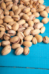 salted pistachios on a blue wooden table
