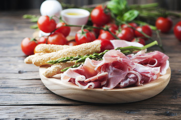 Antipasto with ham and green asparagus