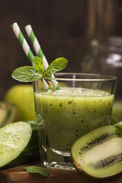 Glass of green refreshing smoothie with kiwi, cucumber and apple. Toned image. Selective focus
