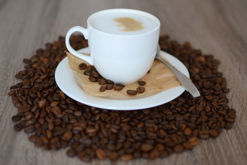 cup of cappuicco and coffee beans