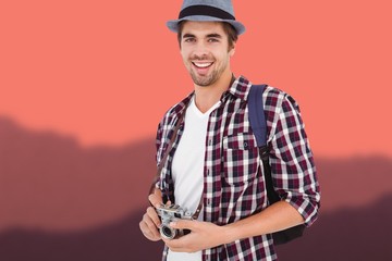 Composite image of portrait of man smiling while holding camera