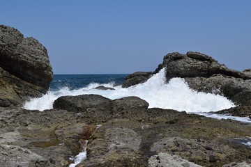 Fototapeta na wymiar 庄内浜の荒波（初夏）／山形県庄内浜の荒波風景を撮影した写真です。庄内浜は非常にきれいな白砂が広がる海岸と、奇岩怪石の磯が続く大変素晴らしい景観のリゾート地です。強風の日の海岸で、荒波を撮影した写真です。