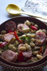 panischer Bohneneintopf  mit Botifarra und Paprika in einer Tonschale