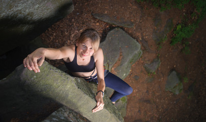 Top view portrait of cute female climber looking up and smiling,