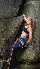 Portrait of young beautiful female climber haning on one hand on