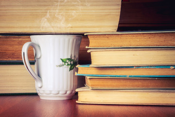 Cup of tea with stack of old books