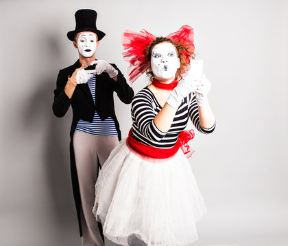 Funny couple of mimes taking a selfie photo on a mobile phone. Concept of  April Fools Day.