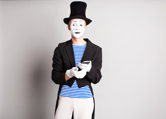 mime with smartphone. Concept of  April Fools Day.