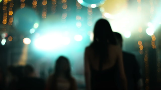 Blurred footage with young attractive people dancing in a nightclub. Girl dancing back to camera.