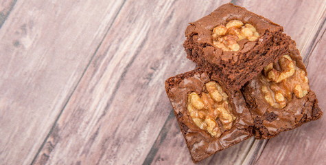 Chocolate walnut brownies over wooden background