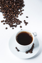 Cup of coffee with coffee beans isolated on white background.