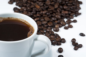 Cup of coffee with coffee beans isolated on white background.