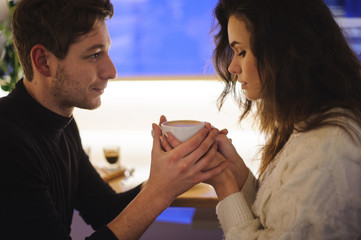 Woman and men holding hot cup